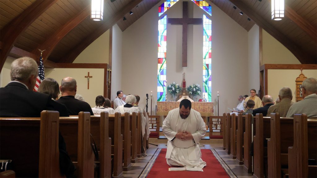 Jon Galles kneeling in aisle x