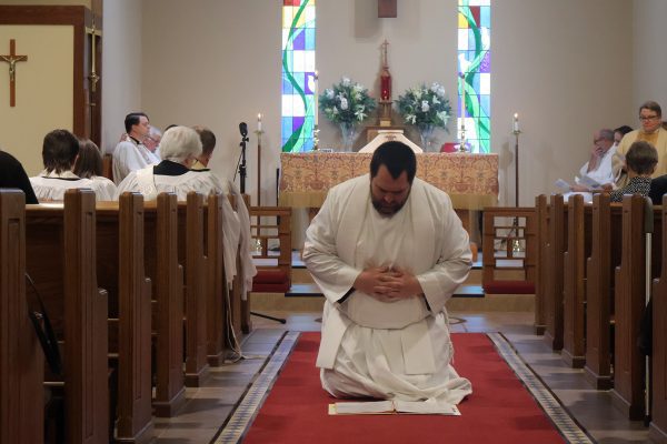 Jon Galles kneeling in aisle