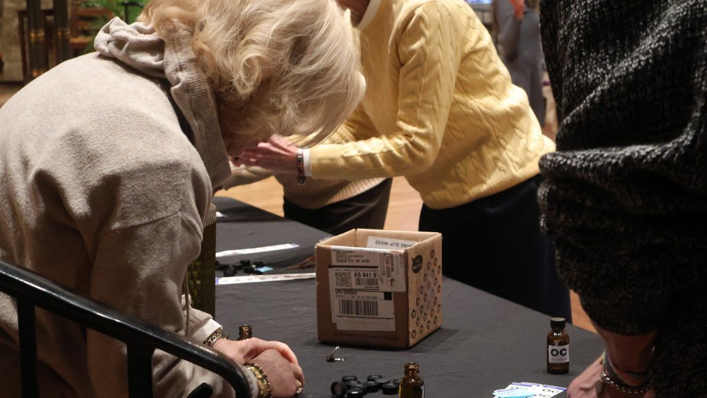 Volunteers filling bottles with oil